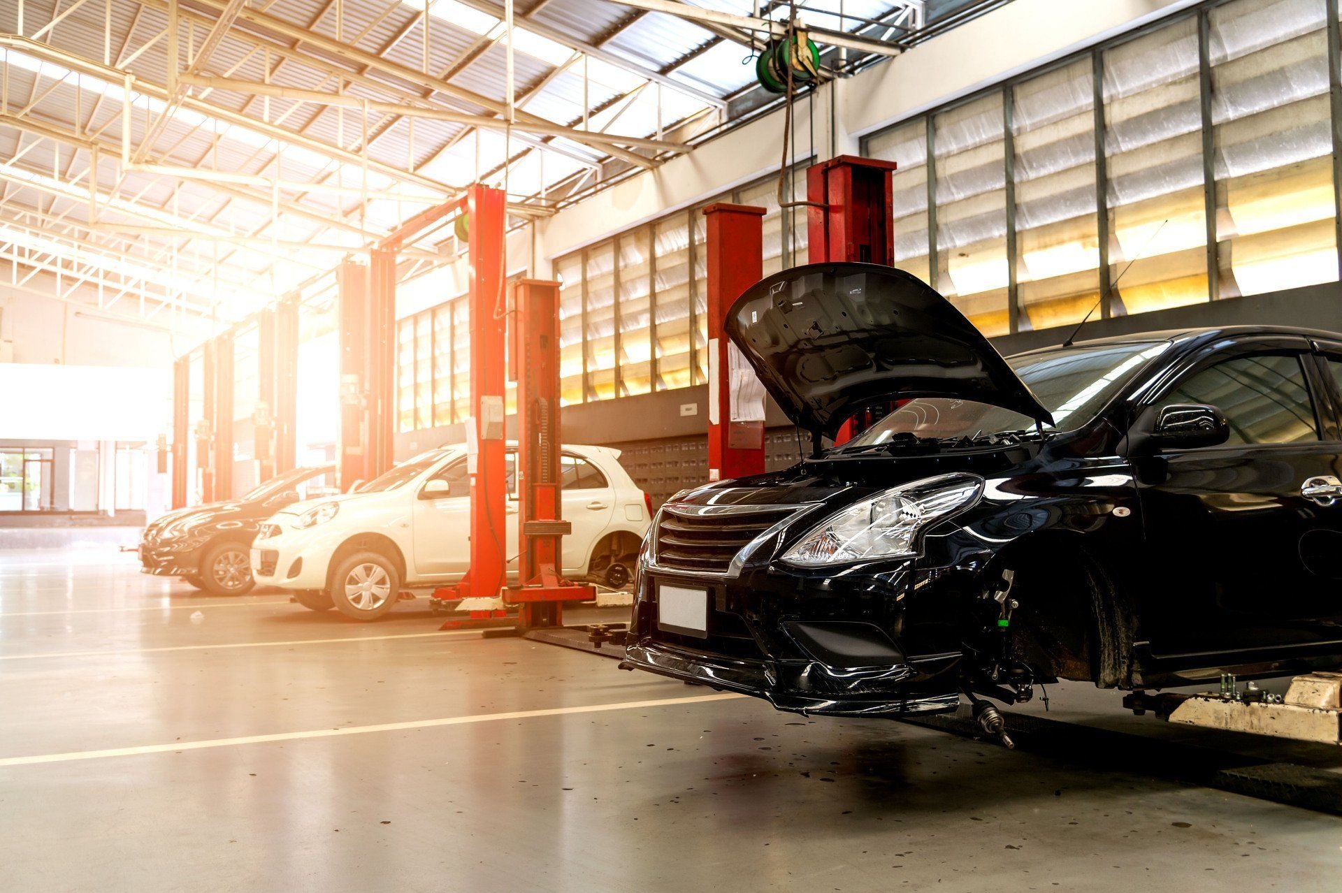 A damaged black vehicle in an auto repair workshop