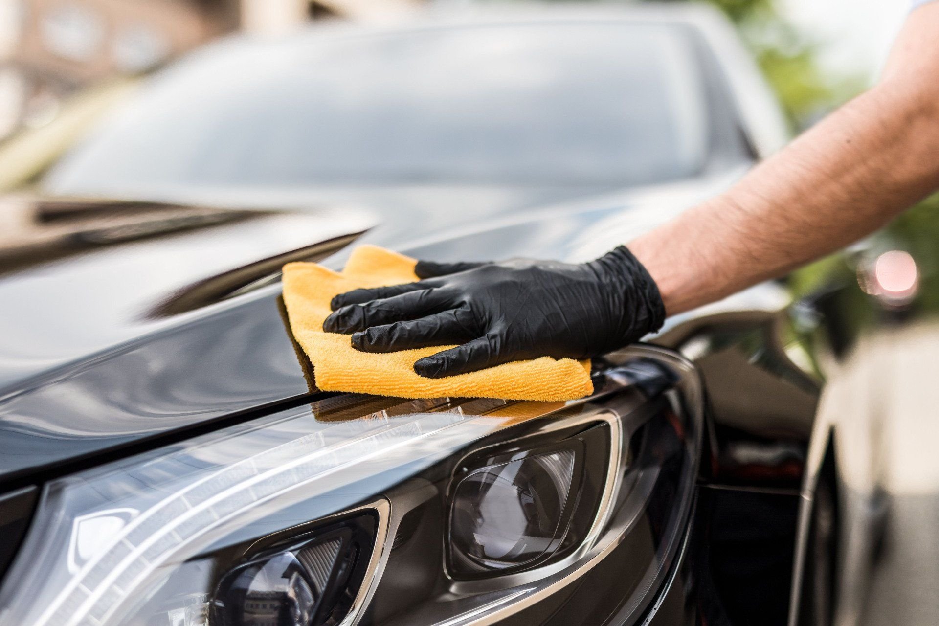 A vehicle finish being cleaned with a microfiber cloth